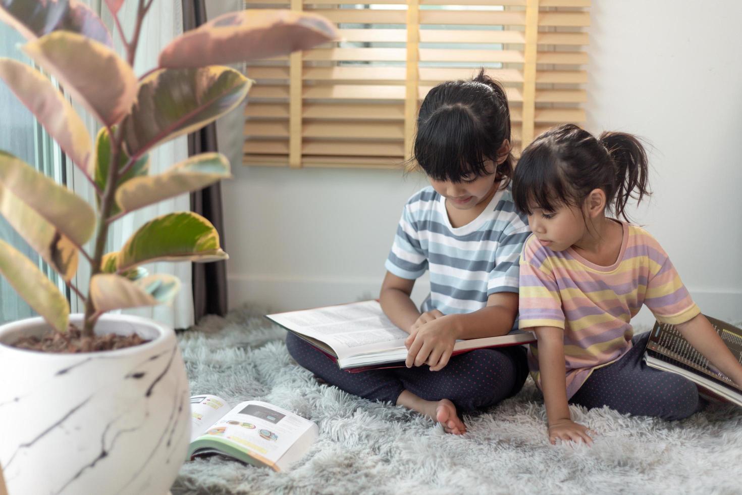 Concentrated siblings reading a book photo