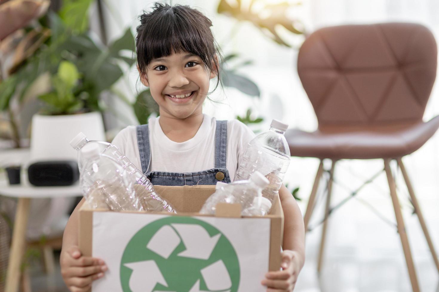 Asian Little girl is separate trash to recycle photo