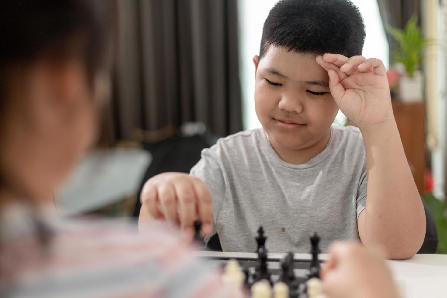 Little boy and little girl are playing chess at home.Children playing chess photo