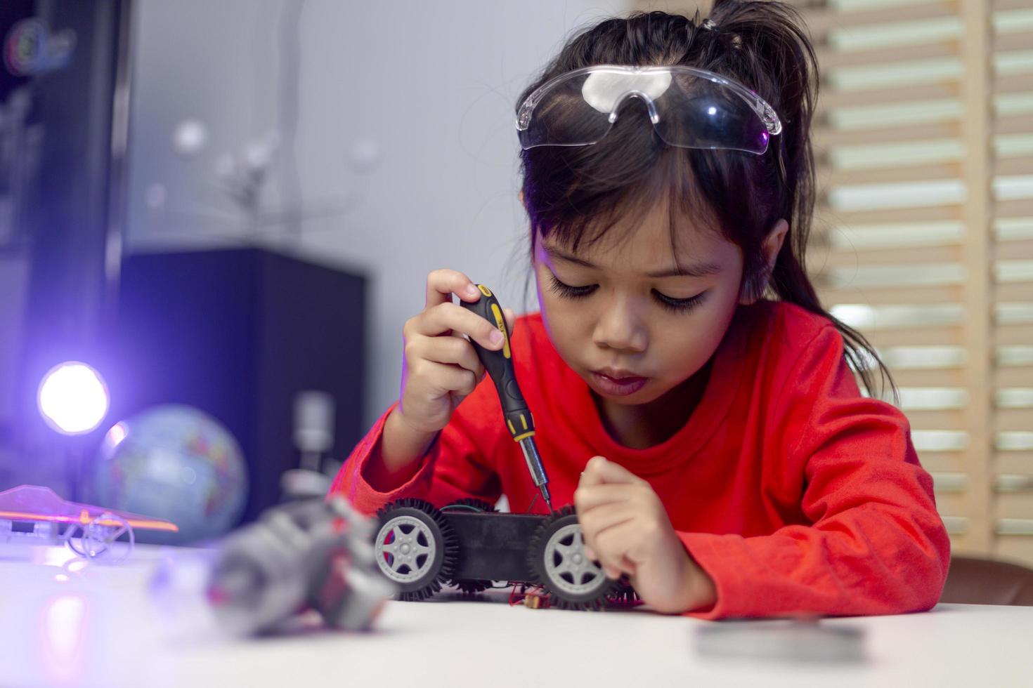 Asia students learn at home in coding robot cars and electronic board cables in STEM, STEAM, mathematics engineering science technology computer code in robotics for kids concept. photo