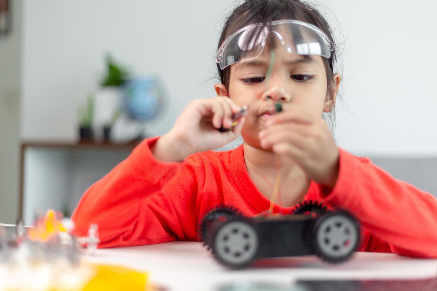 Asia students learn at home in coding robot cars and electronic board cables in STEM, STEAM, mathematics engineering science technology computer code in robotics for kids concept. photo