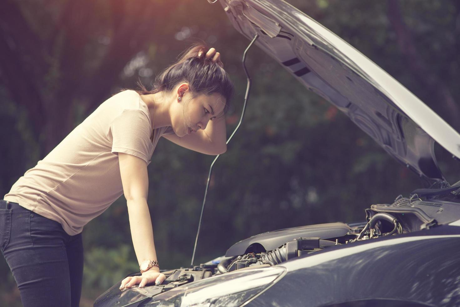 Women spection She opened the hood Broken car on the side See engines that are damaged or not.Vintage color photo