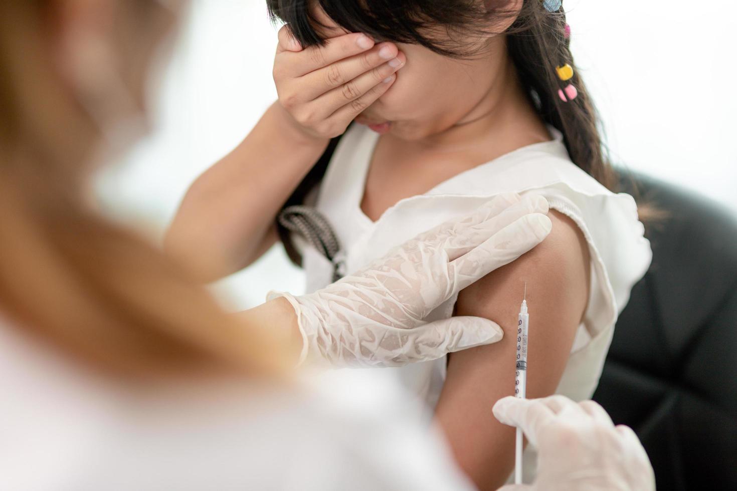 Successful covid-19 vaccination. cute little girl while being immunized against coronavirus photo