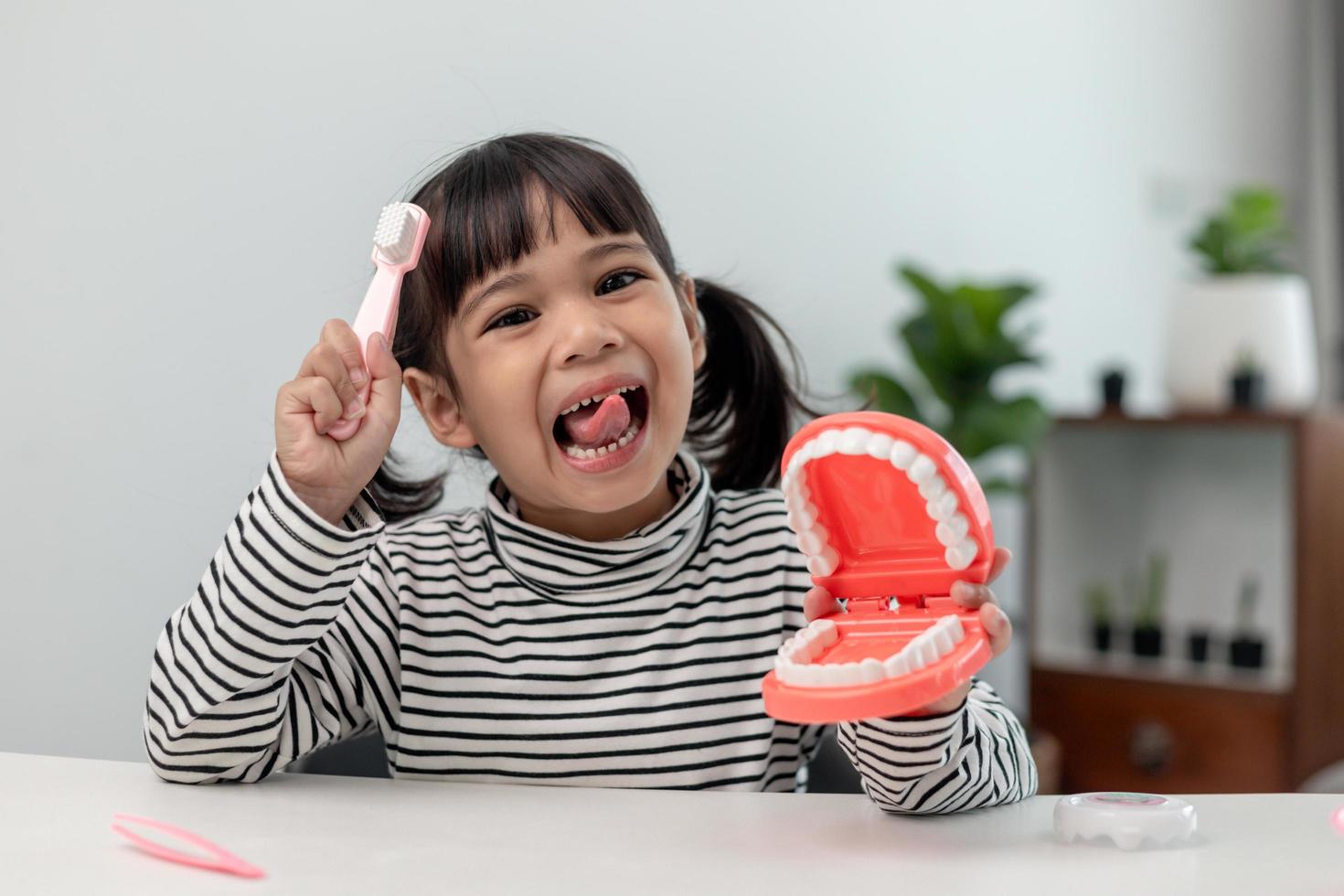 A small child plays with artificial jaws. Children's dentistry. photo