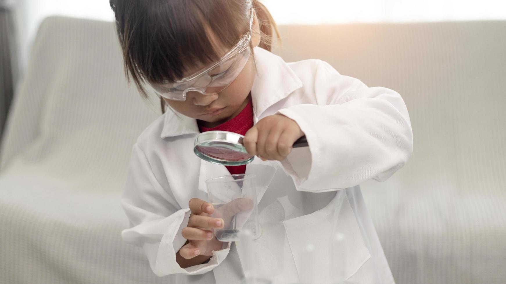 education, science, chemistry, and children concept - kids or students with test tube making experiment at school laboratory photo