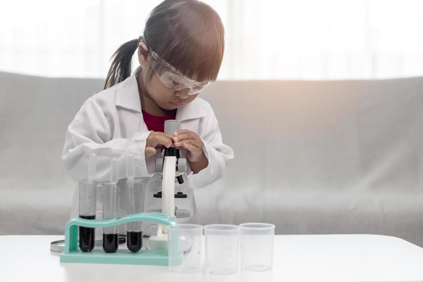 education, science, chemistry, and children concept - kids or students with test tube making experiment at school laboratory photo