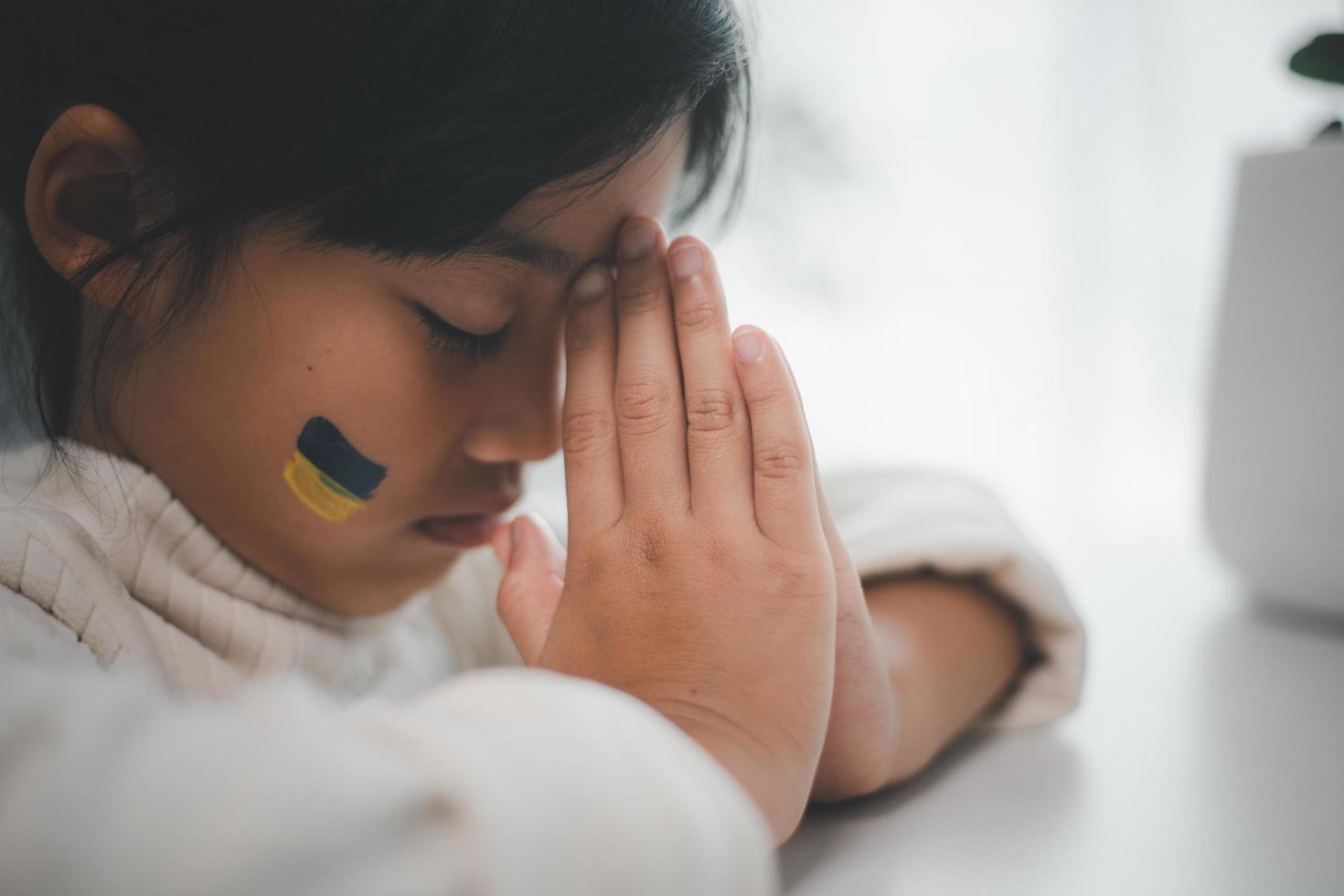 A child with the flag of Ukraine is crying. Sadness longing hope. Children's tears from the war. Evacuation of civilians. Freedom to Ukraine photo
