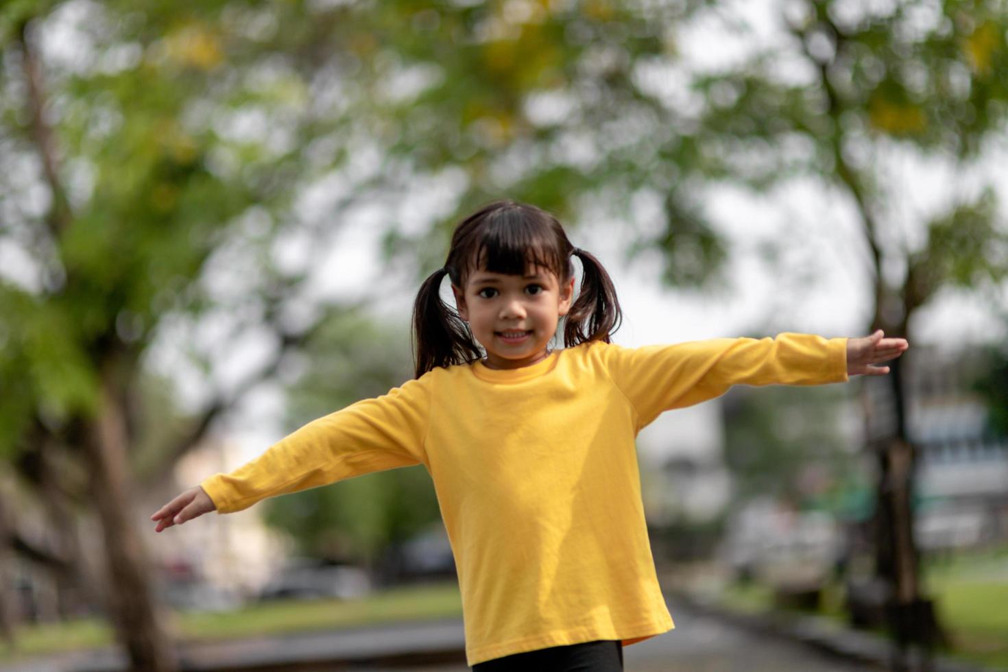 Asian child girl playing on the playground in the outdoor park.Happy moment and good emotion photo