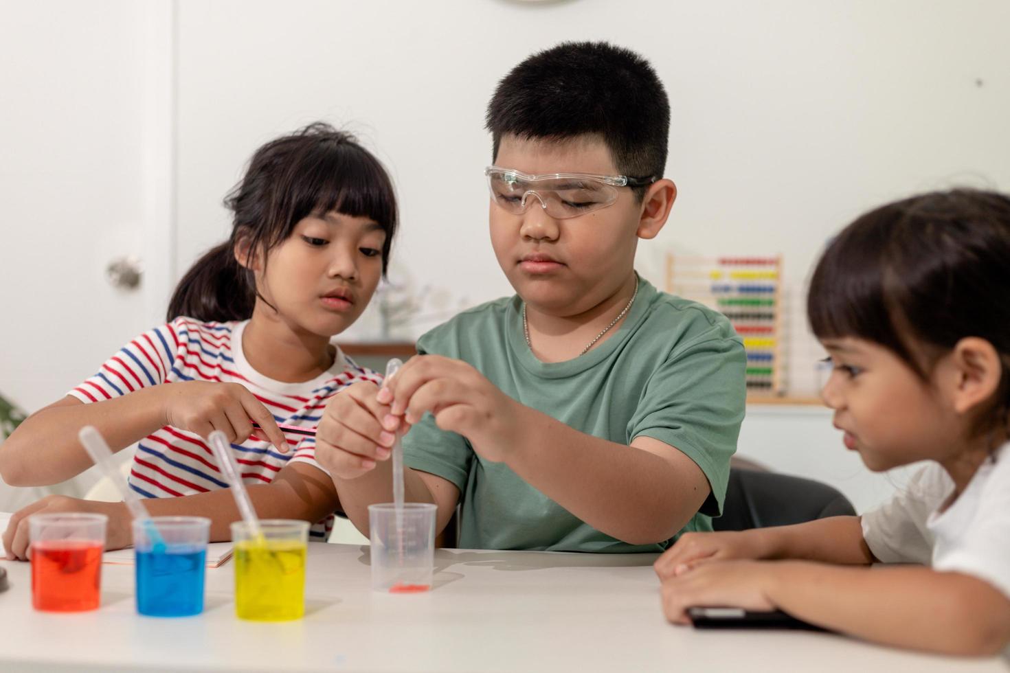 Asian kids do chemical experiments in their home photo