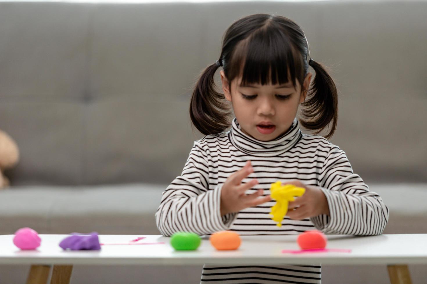 los niños asiáticos juegan con formas de moldeo de arcilla, aprendiendo a través del juego foto