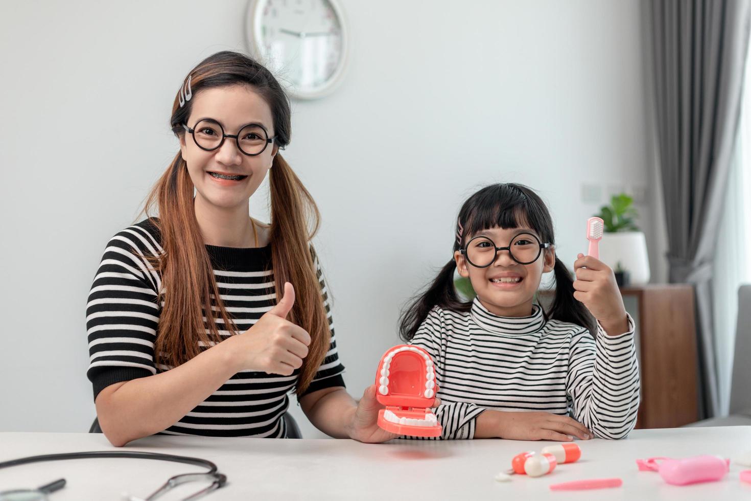 mother teaching daughter child teeth brushing at home photo