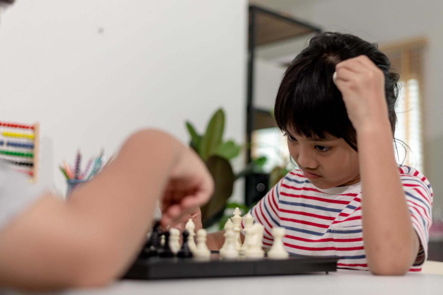 Little boy and little girl are playing chess at home.Children playing chess photo