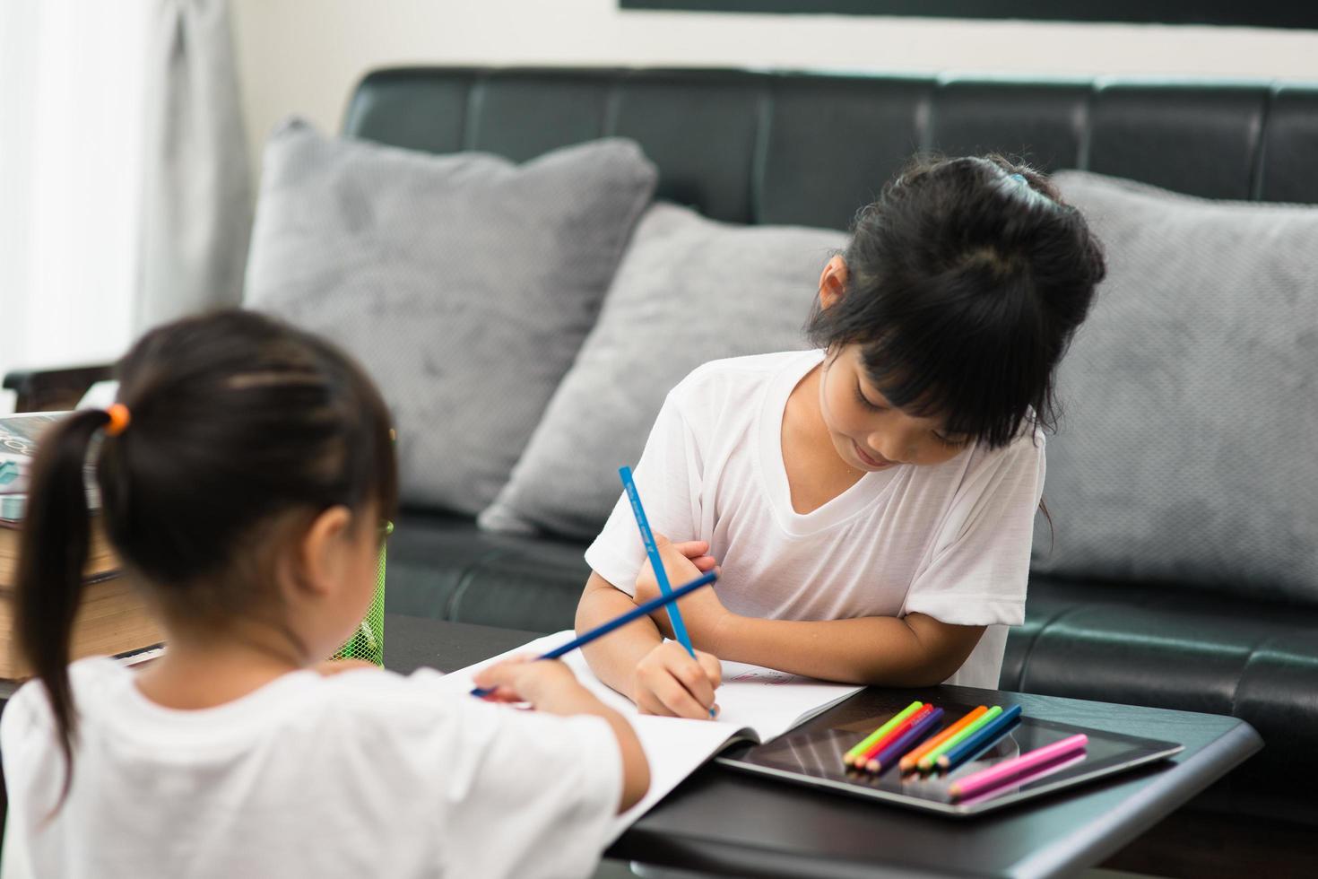 coronavirus covid-19 y aprendizaje desde el hogar, concepto de niño escolar en casa. los niños pequeños estudian en línea aprendiendo desde casa con una computadora portátil. foto