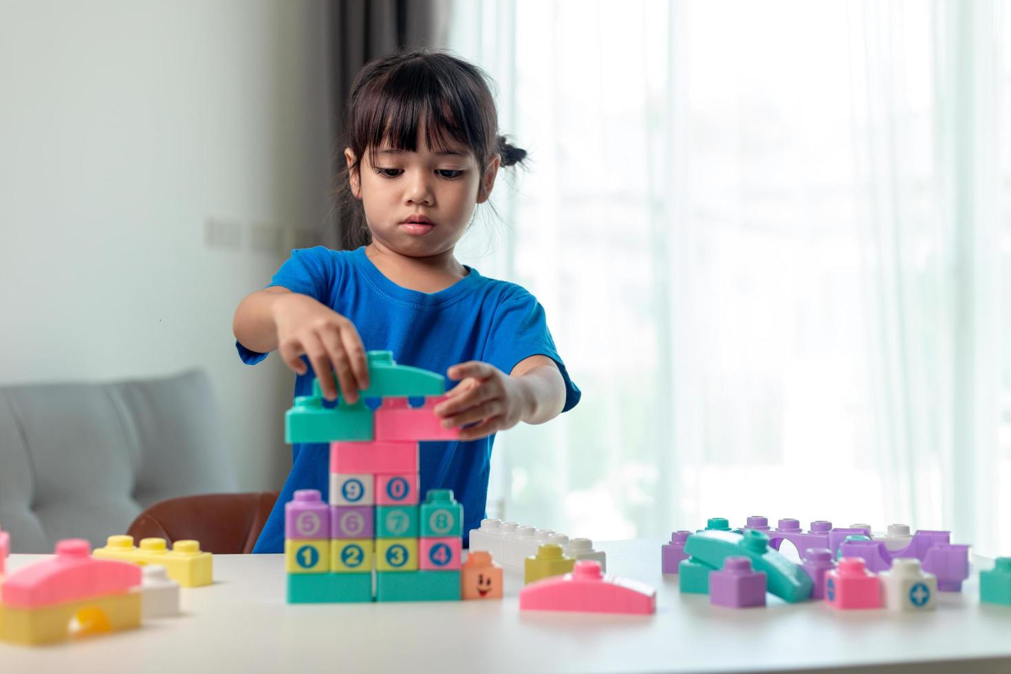 Little child girl playing colorful blocks photo