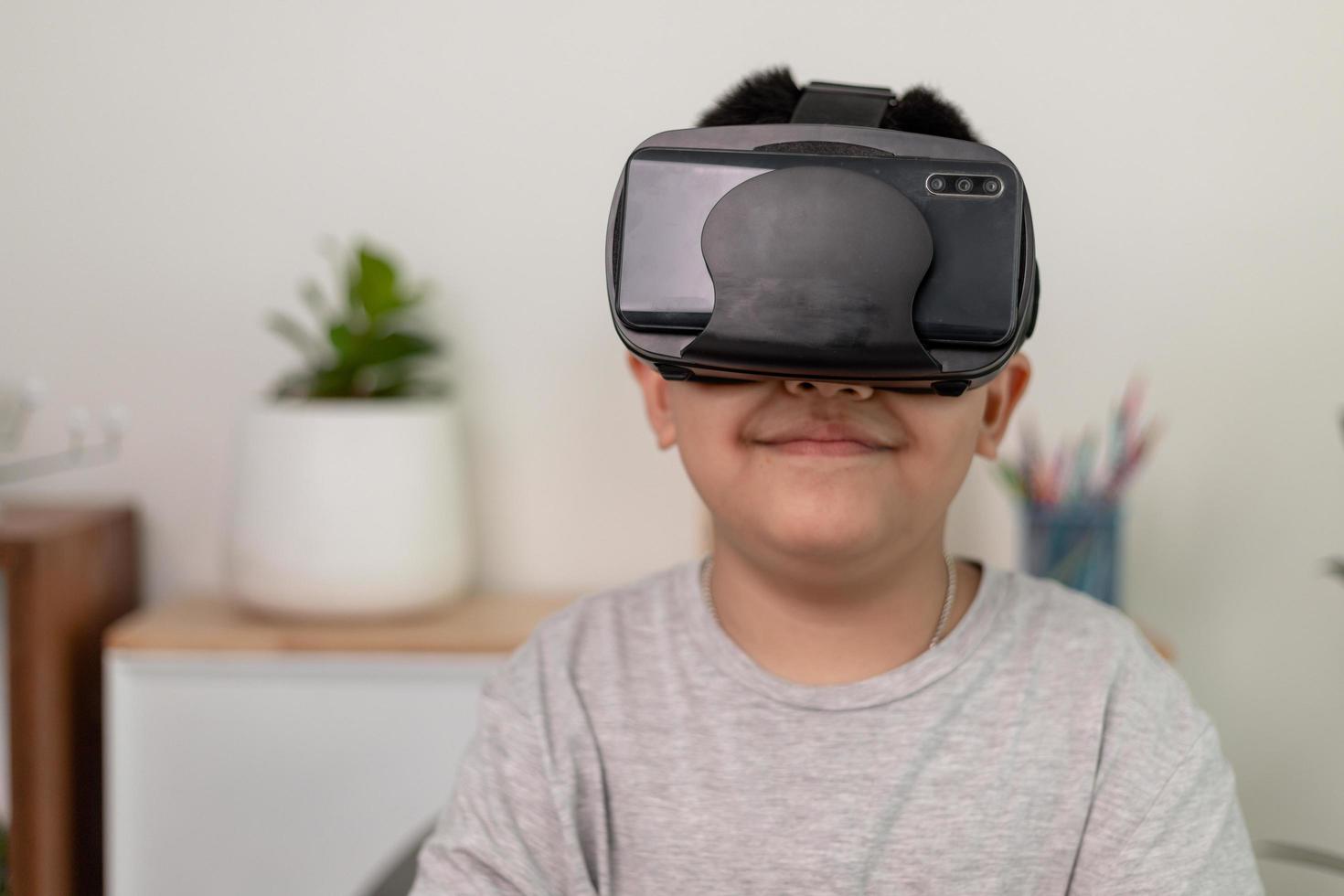 Asian Little boy with VR glasses studying sciences at home,curious student wears a virtual reality headset to study science home online study futuristic lifestyle learning photo