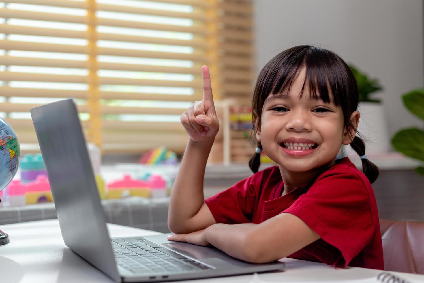 Asian girl using Laptop computer for online study homeschooling during home quarantine. homeschooling, online study, home quarantine, online learning, corona virus or education technology concept photo