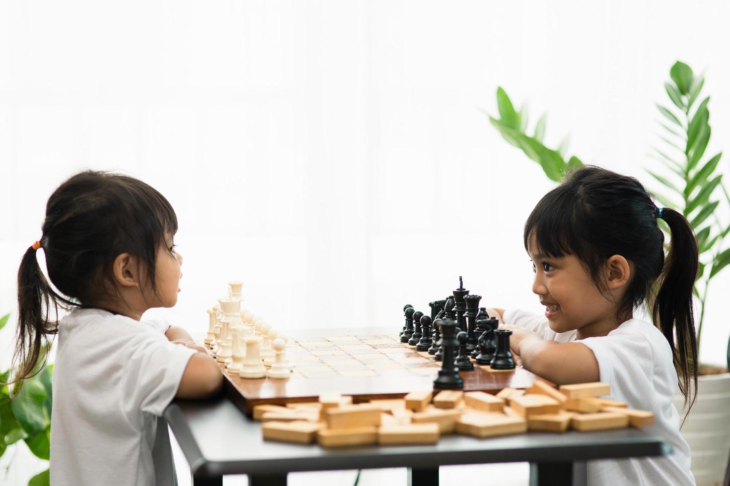 Two cute children playing chess at home photo