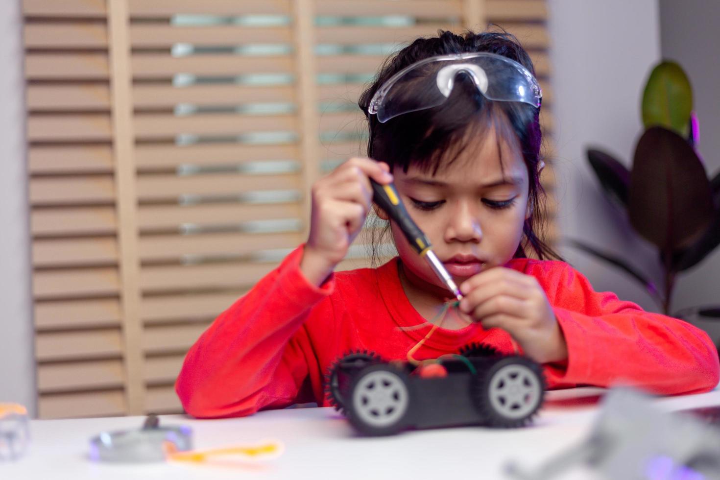 Asia students learn at home in coding robot cars and electronic board cables in STEM, STEAM, mathematics engineering science technology computer code in robotics for kids concept. photo