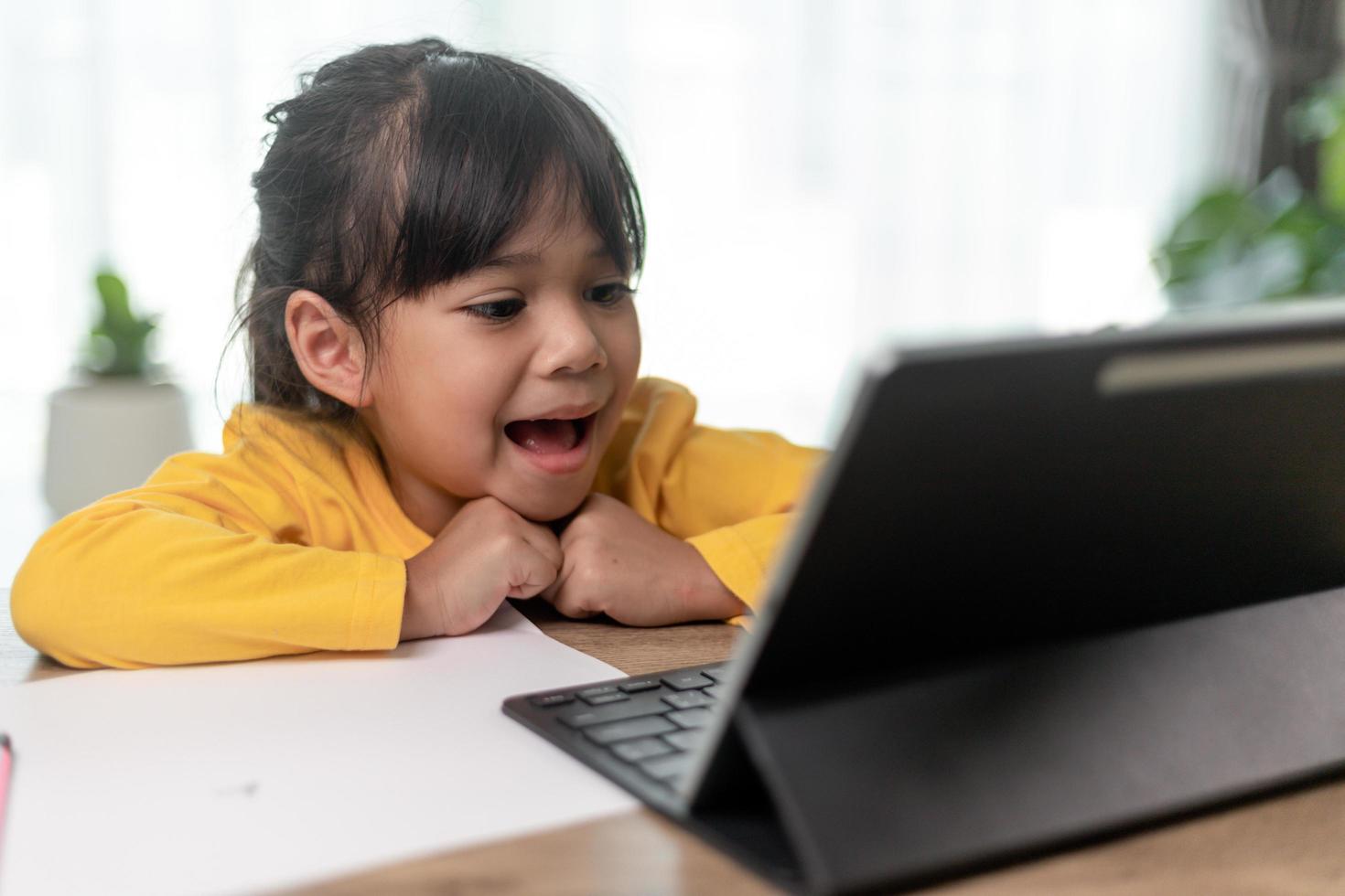 Asian little girl taking class on line and happy for Homeschool Quarantine coranavirus pandemic concept photo