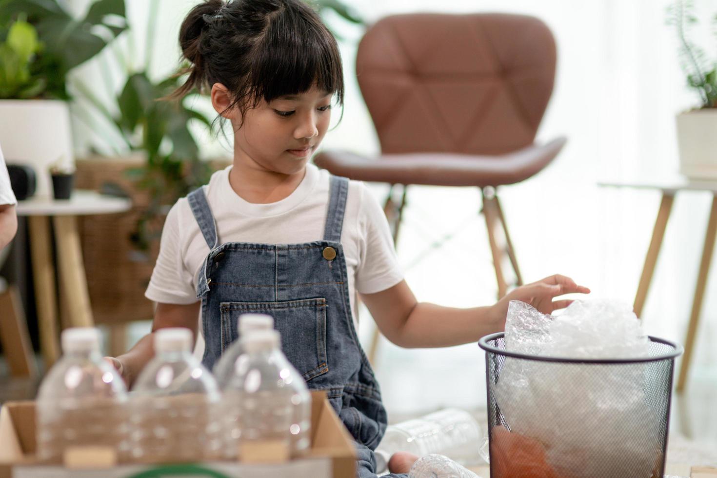 Asian Little girl is separate trash to recycle photo