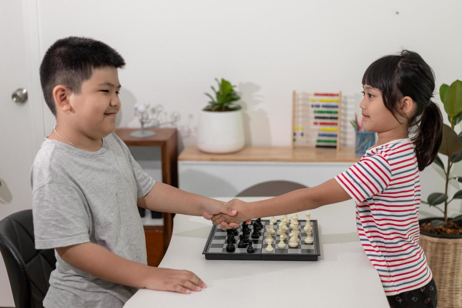 Little boy and little girl are playing chess at home.Children playing chess photo