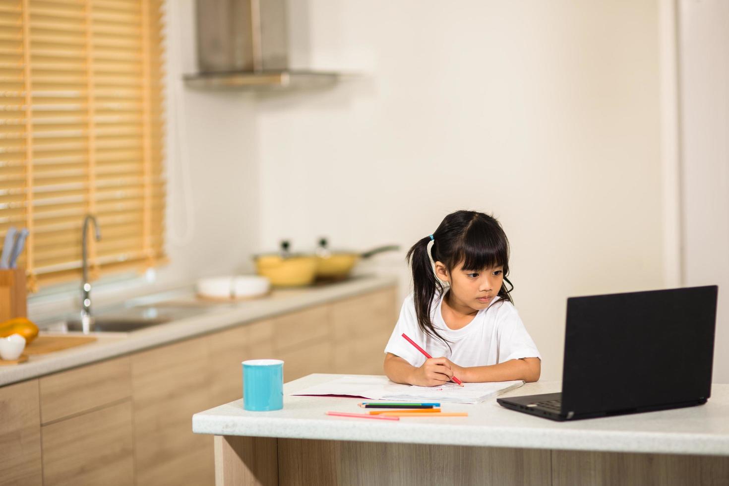 Coronavirus Outbreak. Lockdown and school closures. Schoolgirl watching online education class, happy talking with teacher on the internet at home. COVID-19 pandemic forces children online learning photo