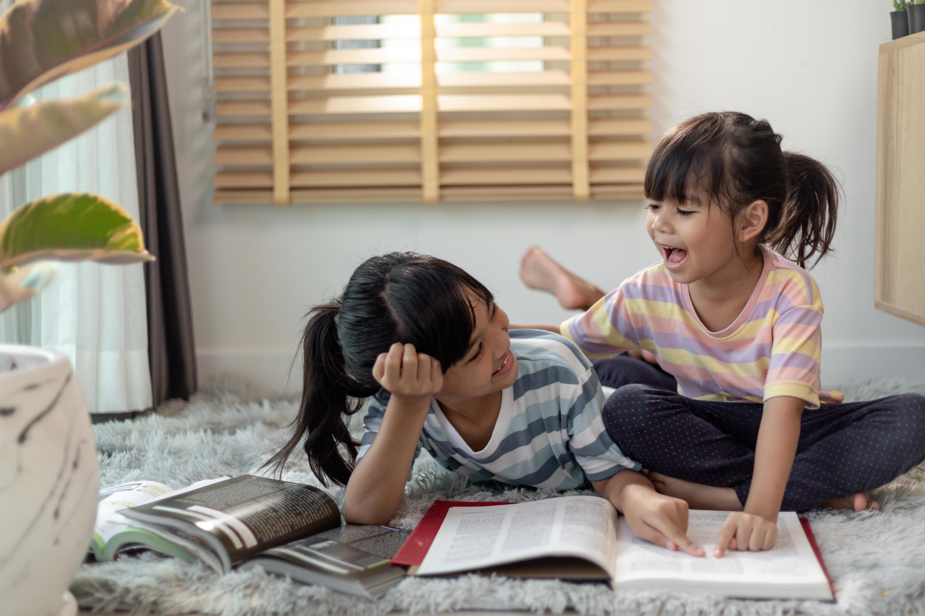 Concentrated siblings reading a book 8428348 Stock Photo at Vecteezy