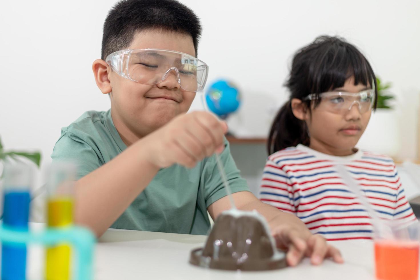 Kids repeating and observing a science lab project at home - the baking soda and vinegar volcano photo