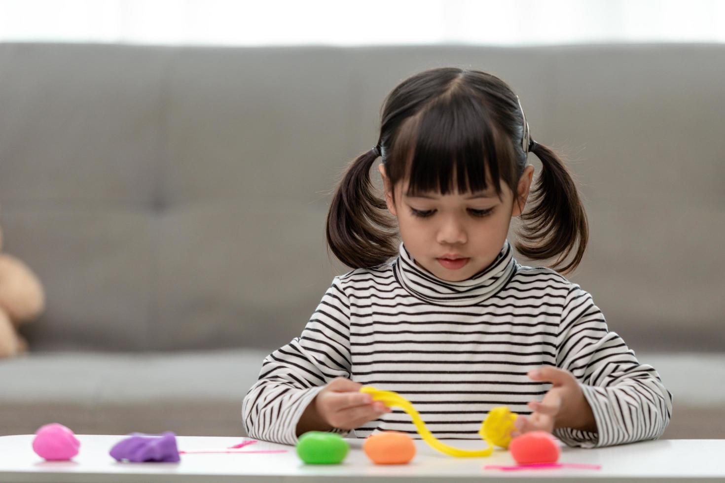 Asian kids play with clay molding shapes, learning through play photo