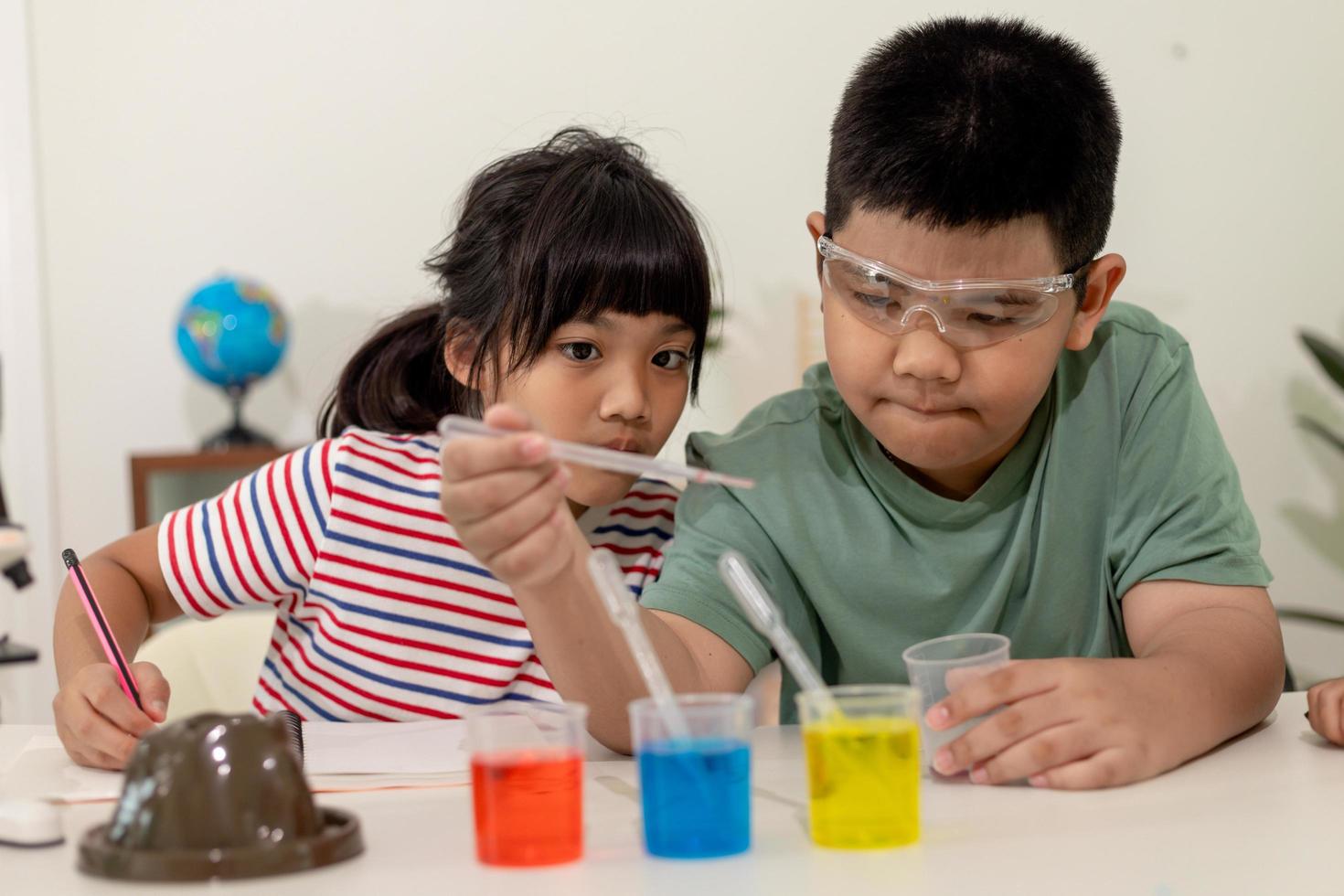 niños asiáticos hacen experimentos químicos en su casa foto