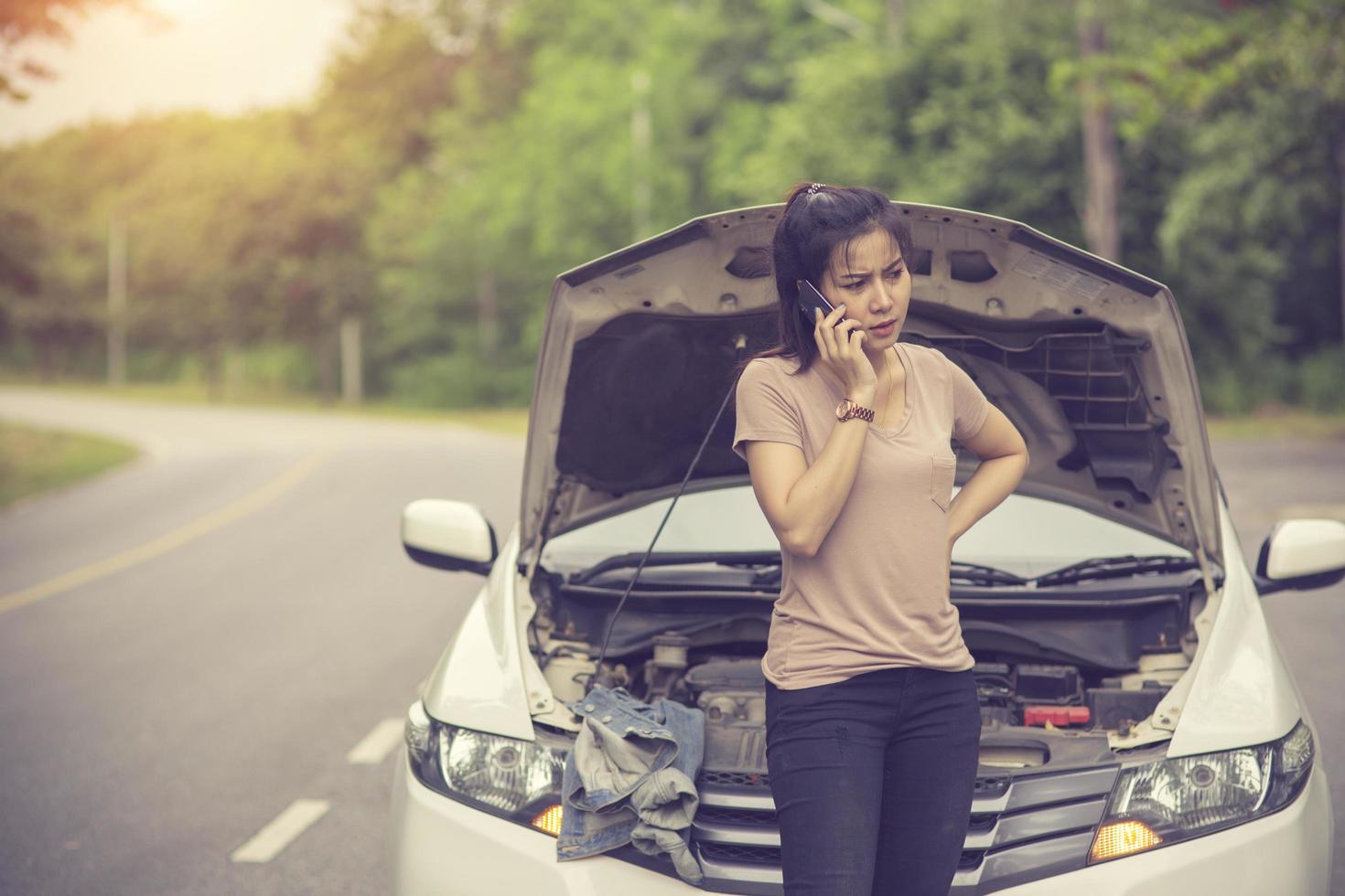 Young woman with broken car calling for help.Vintage color photo