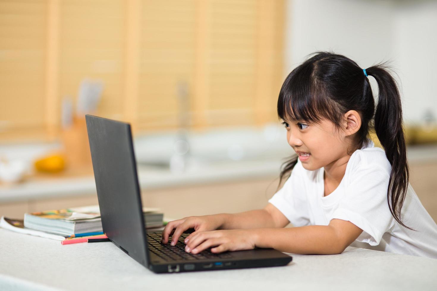 Coronavirus Outbreak. Lockdown and school closures. Schoolgirl watching online education class, happy talking with teacher on the internet at home. COVID-19 pandemic forces children online learning photo