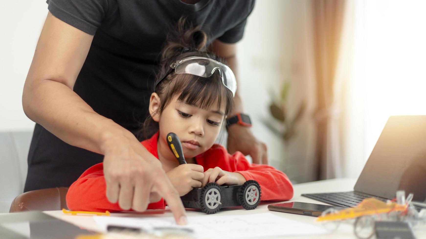 STEM education, Asian girl and father learning programming process of new robot technology. Happy family members relationship, Studying anywhere anytime to learn together at home photo