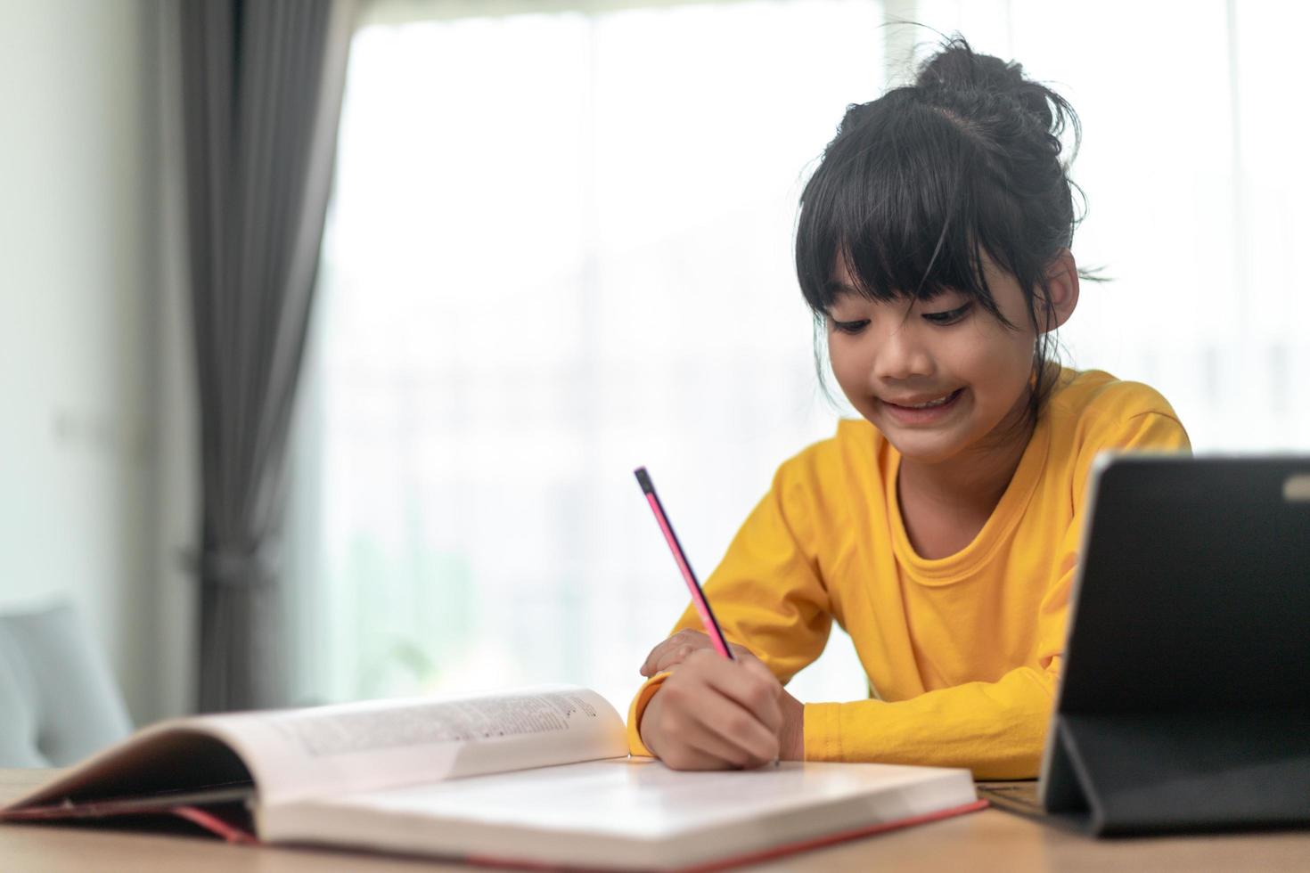 Asian little girl taking class on line and happy for Homeschool Quarantine coranavirus pandemic concept photo