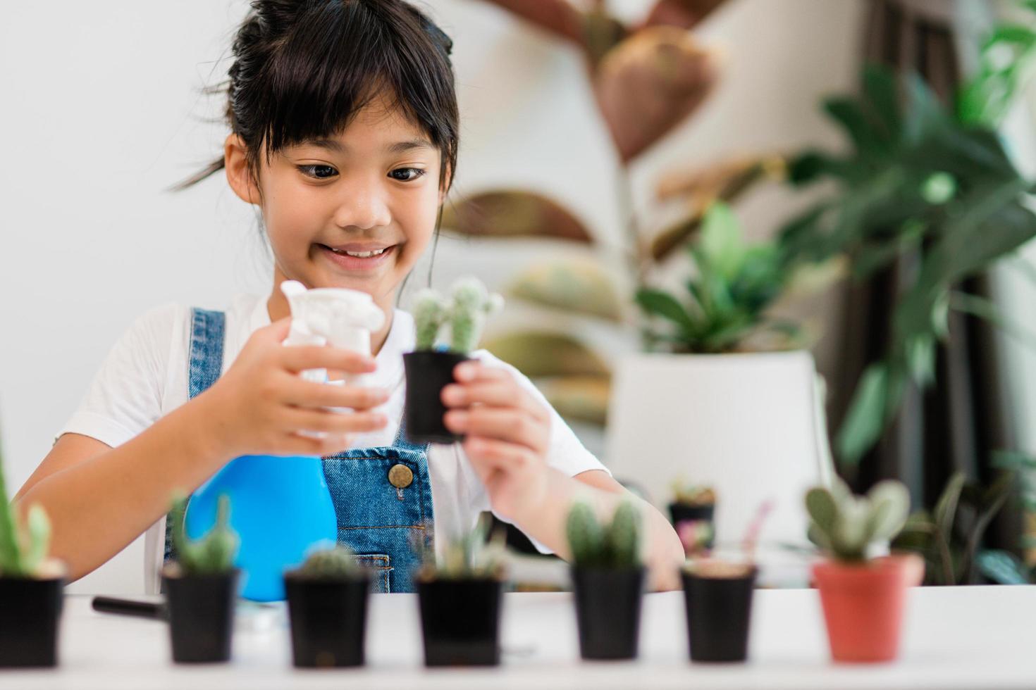 kid gently touch new stem of the cactus he grows with care, one hand holds magnifying glass.Nature education, Montessori and observation skills concept. photo