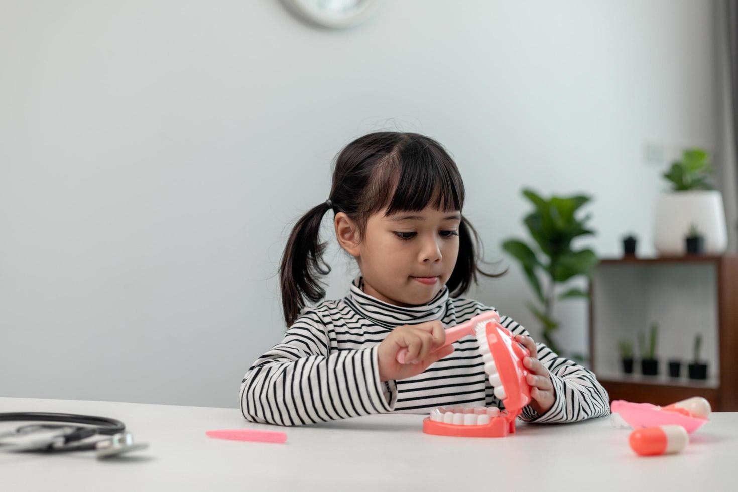 A small child plays with artificial jaws. Children's dentistry. photo