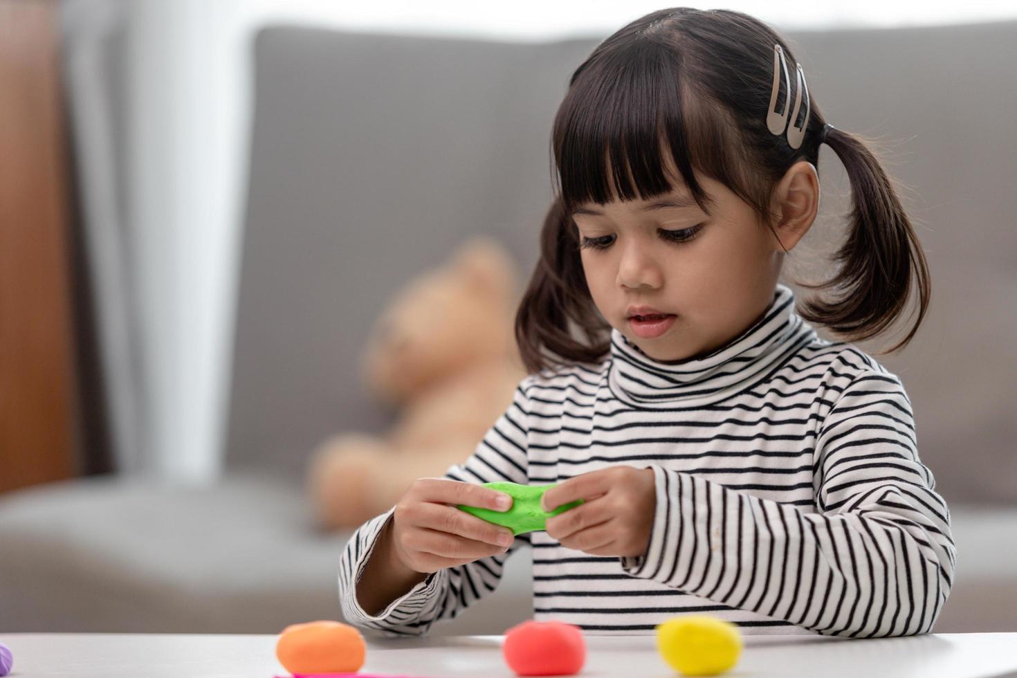 Asian kids play with clay molding shapes, learning through play photo