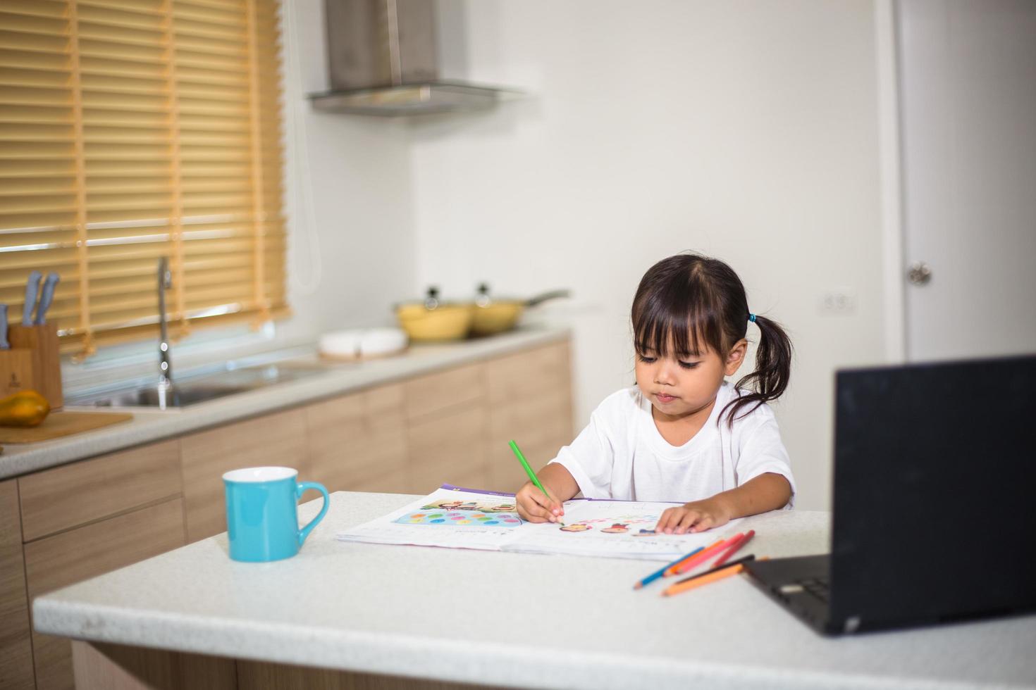 Coronavirus Outbreak. Lockdown and school closures. Schoolgirl watching online education class, happy talking with teacher on the internet at home. COVID-19 pandemic forces children online learning photo