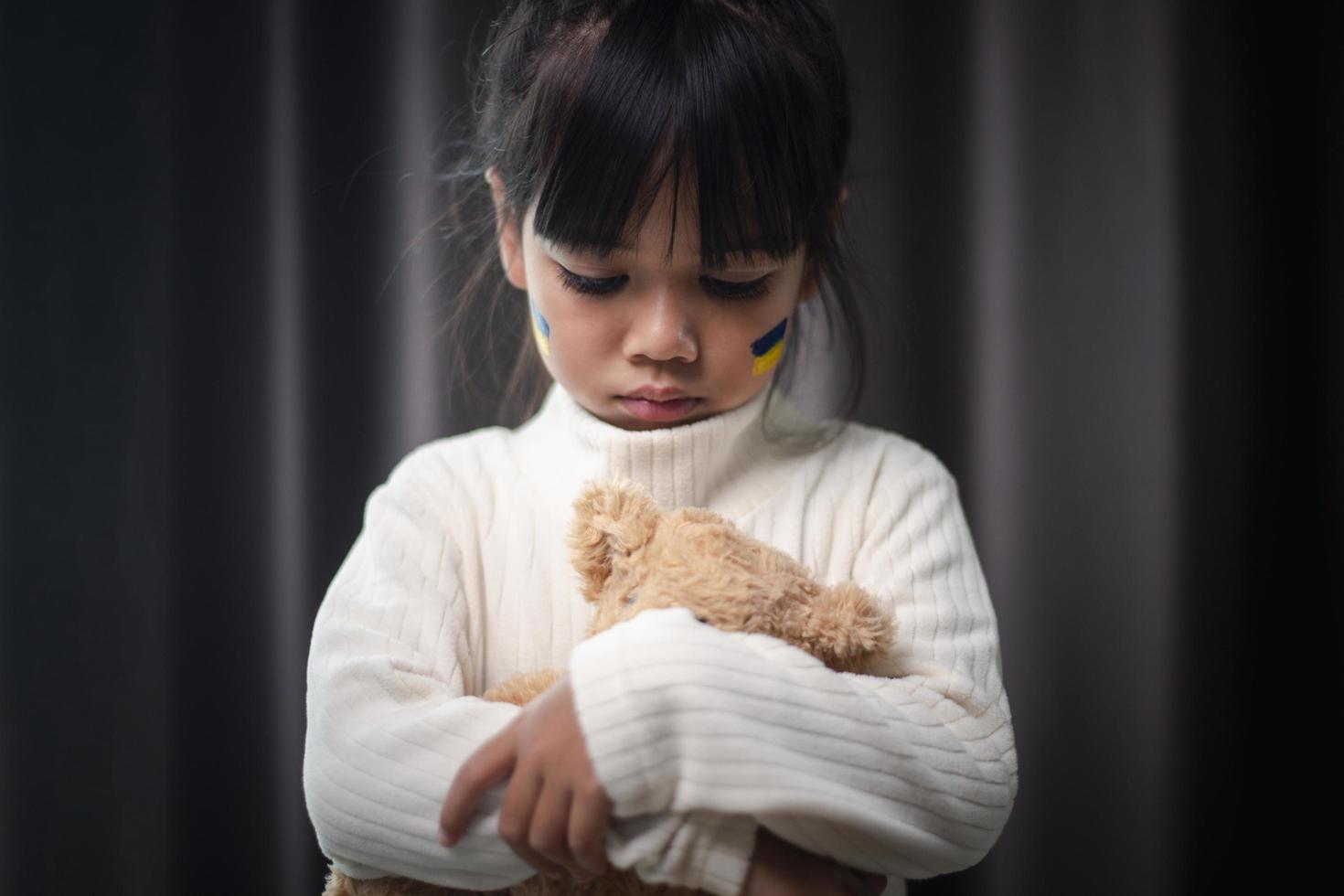 A child with the flag of Ukraine is crying. Sadness longing hope. Children's tears from the war. Evacuation of civilians. Freedom to Ukraine photo