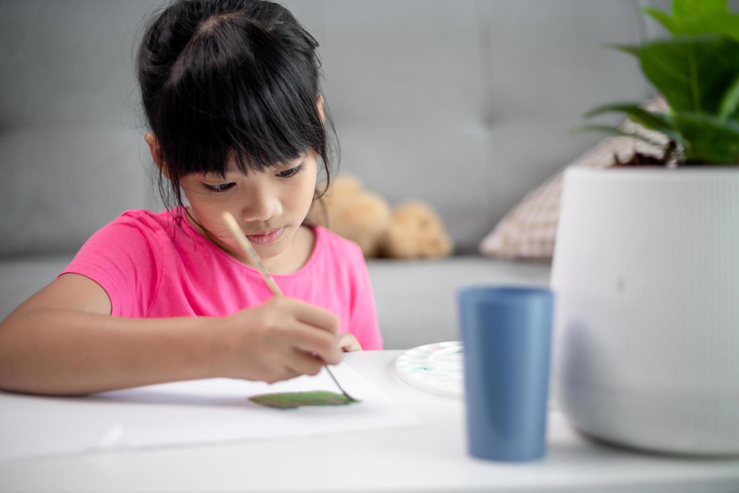 Girl Painting Picture On Table At Home photo