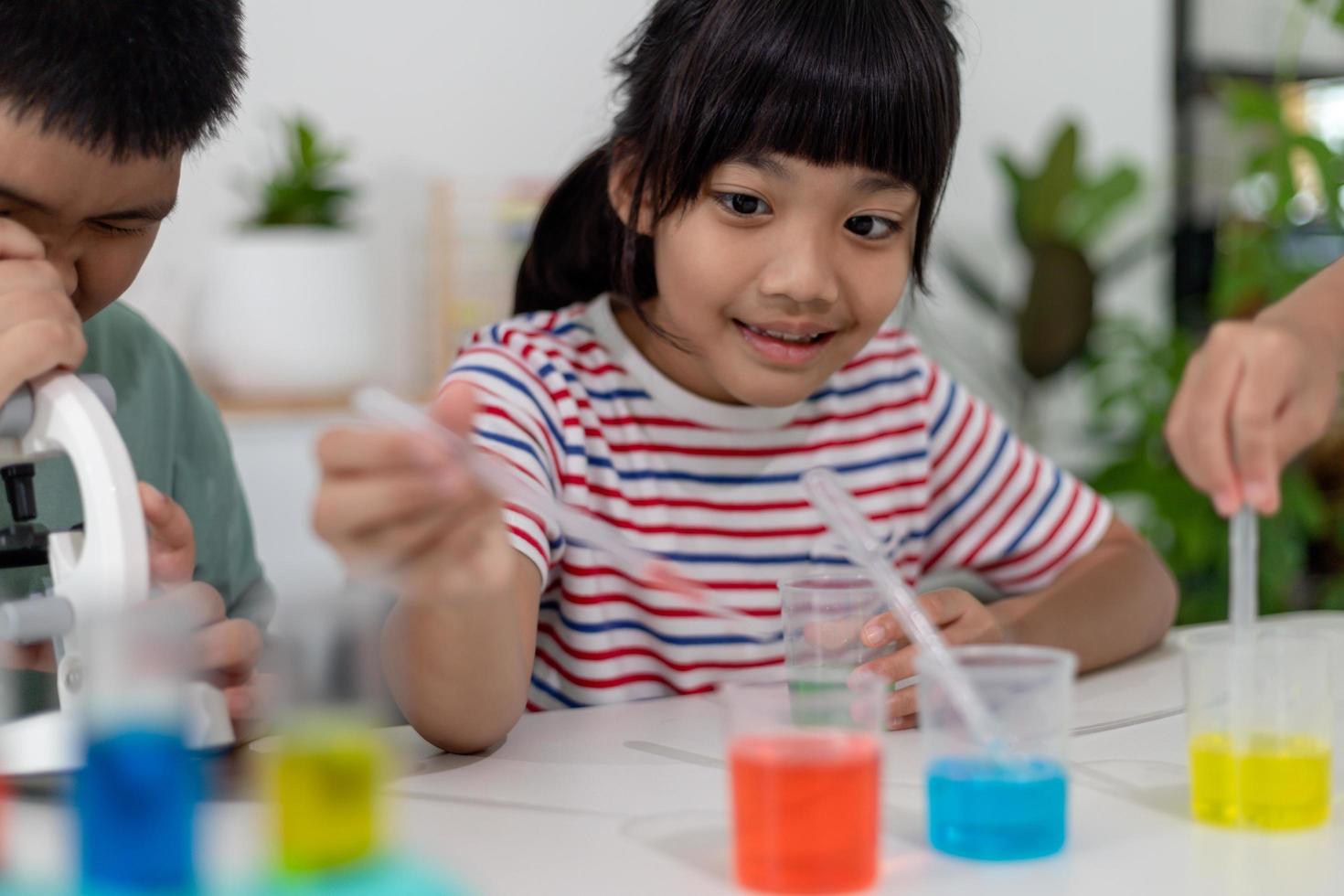 Asian Children enthusiastically watch chemistry experiments. photo