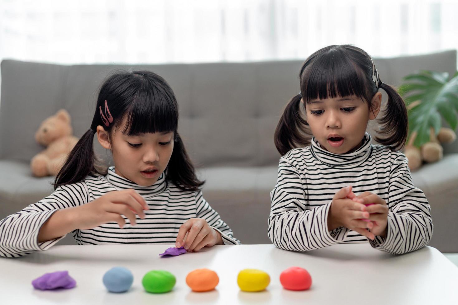 los niños asiáticos juegan con formas de moldeo de arcilla, aprendiendo a través del juego foto