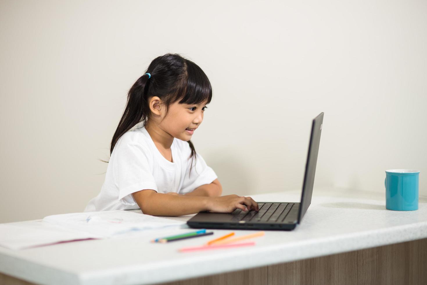 Coronavirus Outbreak. Lockdown and school closures. Schoolgirl watching online education class, happy talking with teacher on the internet at home. COVID-19 pandemic forces children online learning photo