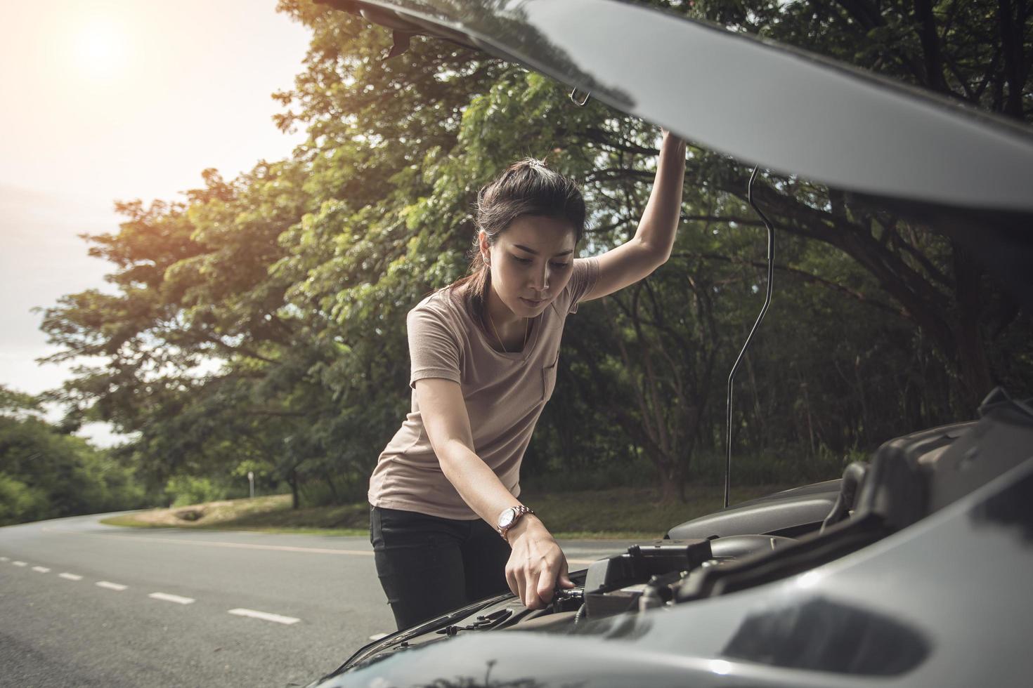 Women spection She opened the hood Broken car on the side See engines that are damaged or not.Vintage color photo