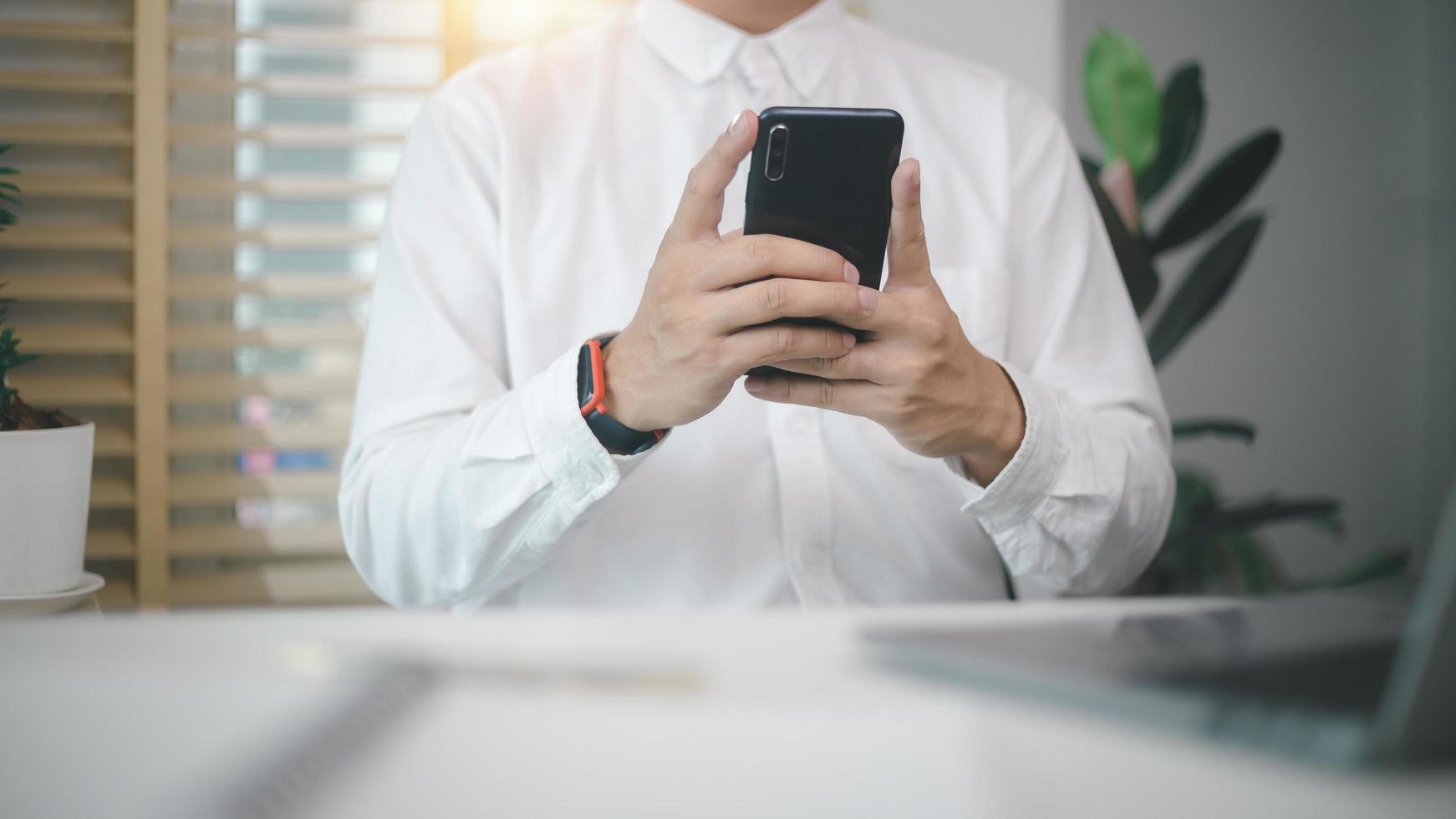 businessman using smartphone and computer working remotely from modern home office.  student having virtual training on cellphone texting using online tech applications. photo