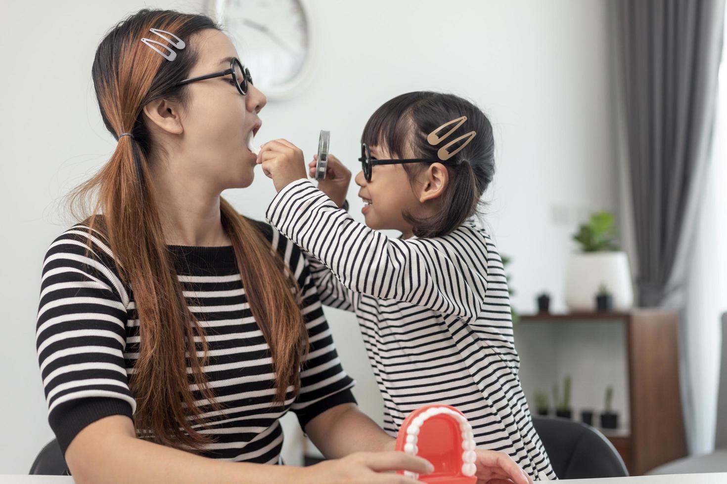 Future doctor checking mother's denture at the home. photo