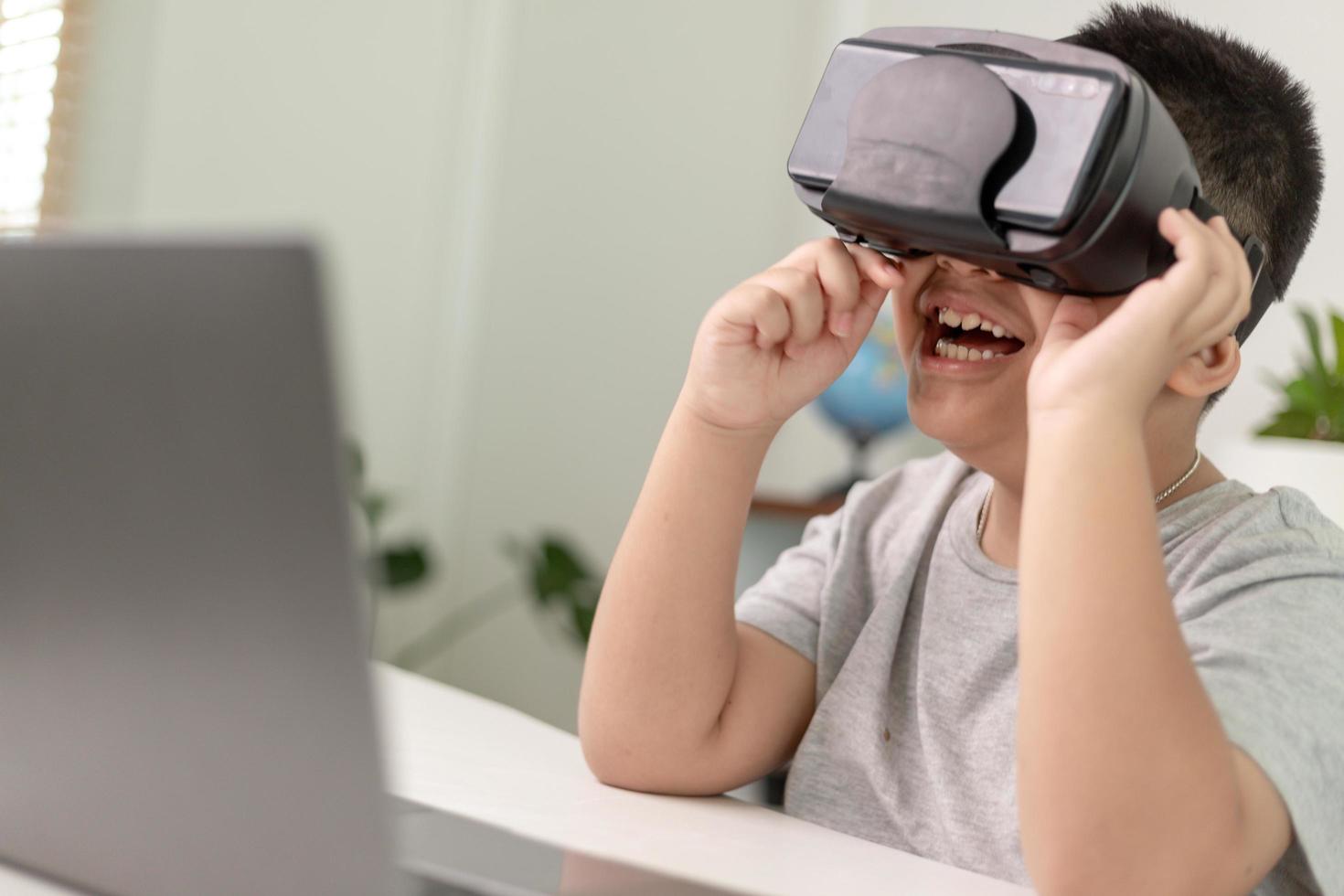 Asian Little boy with VR glasses studying sciences at home,curious student wears a virtual reality headset to study science home online study futuristic lifestyle learning photo