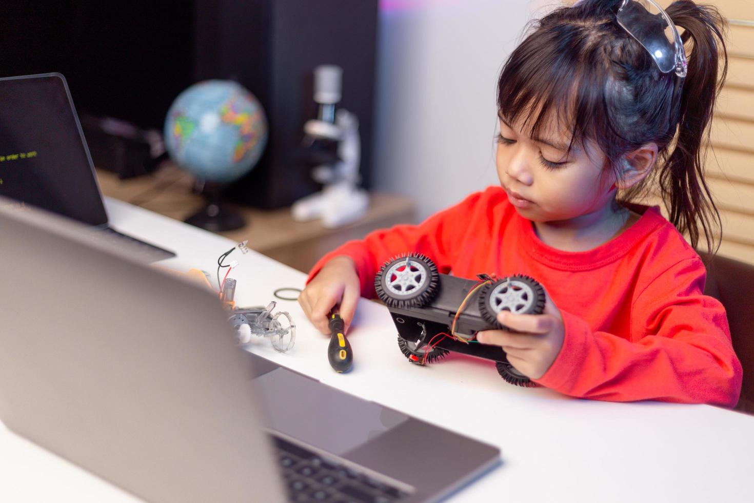 Asia students learn at home in coding robot cars and electronic board cables in STEM, STEAM, mathematics engineering science technology computer code in robotics for kids concept. photo