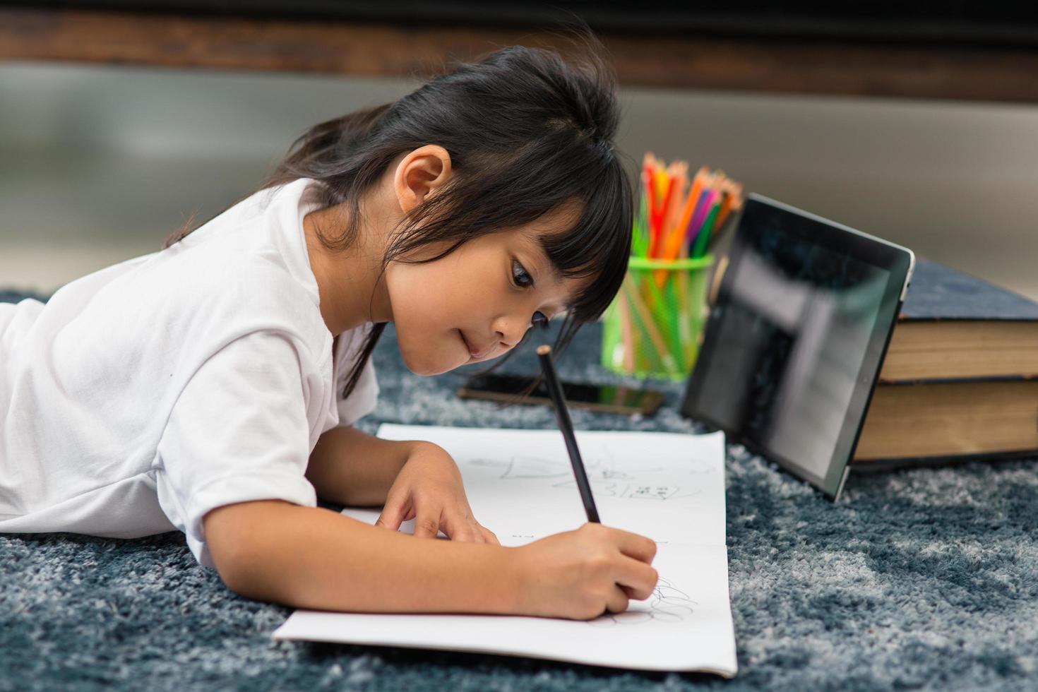 Portrait of preschool kid using tablet for his homework,Soft focus of Child doing homework by using digital tablet searching information on internet,E-learning or Home schooling education concept photo