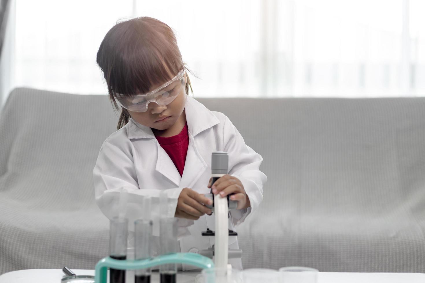 education, science, chemistry, and children concept - kids or students with test tube making experiment at school laboratory photo